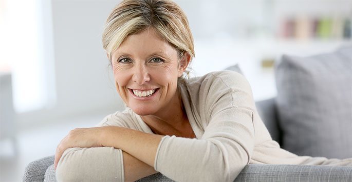smiling Blonde Woman sitting on a Couch