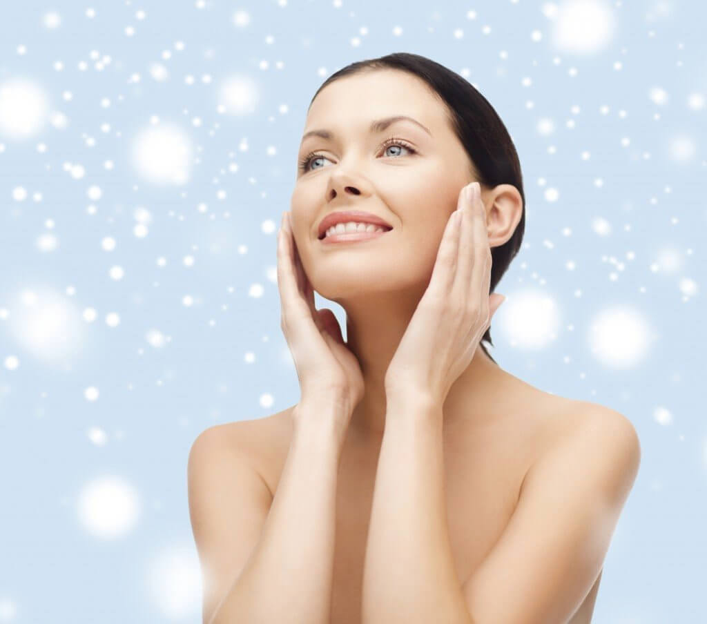 Woman touching her face in front of a snowy background