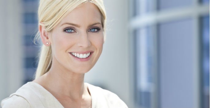 Woman with blonde hair in a ponytail smiling