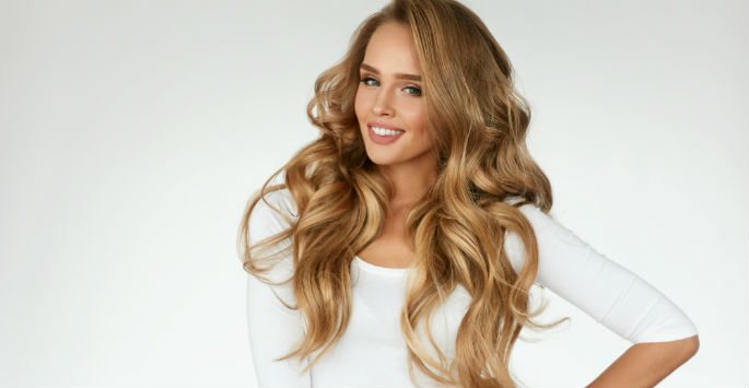 Young woman with long wavy blonde hair smiling
