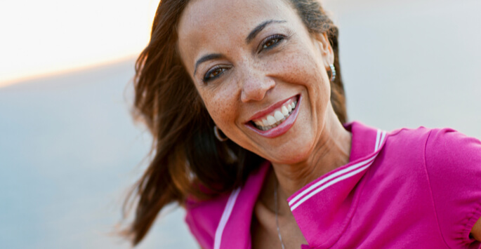 Woman in a pink polo shirt smiling
