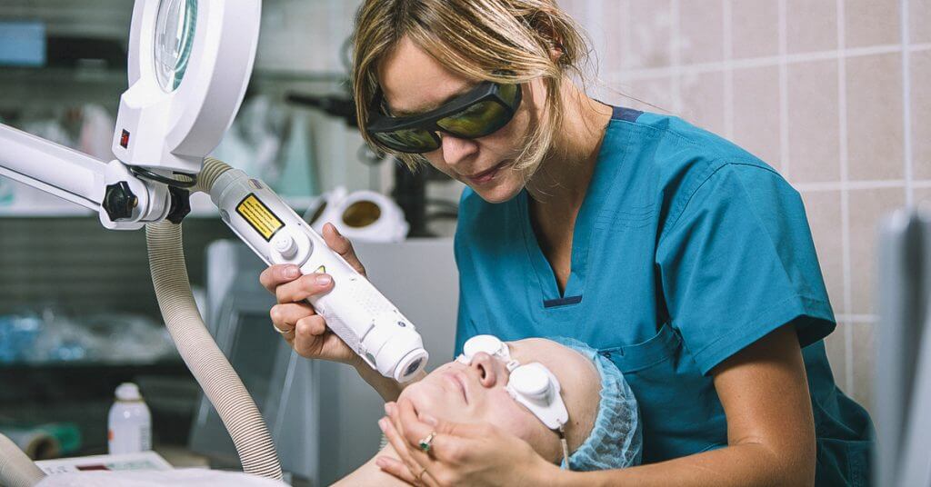 Doctor administering a laser treatment to a patient
