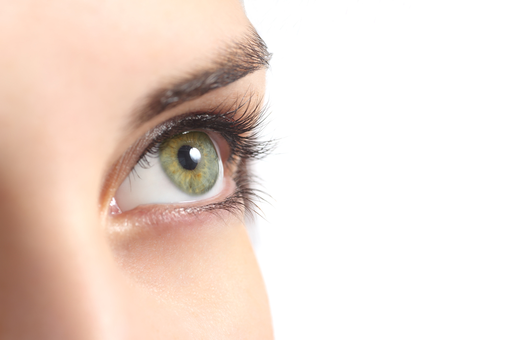 Close-up of a woman's green eye with long lashes