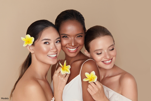 Three relaxed women smiling and holding flowers