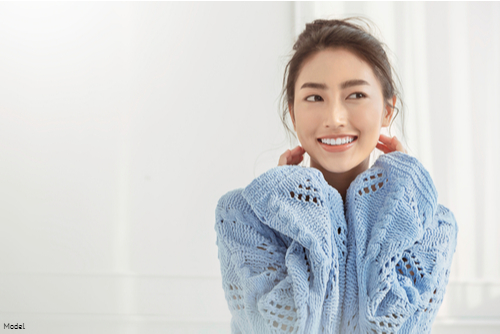 Young woman wearing a light blue sweater smiling