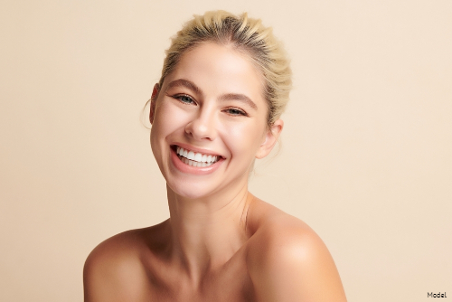 Blonde woman with her hair tied back smiling joyfully